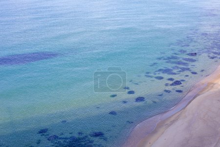 Téléchargez les photos : Gangneung City, Corée du Sud - 29 juillet 2019 : Une vue aérienne rapprochée de la plage de Mangsang révèle les eaux transparentes de la mer de l'Est qui rencontrent la plage de sable, avec des motifs de sable visibles et des algues sous les douces vagues. - en image libre de droit