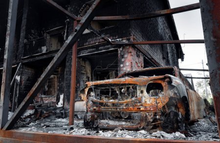 Foto de Un coche destruido quemado cerca de un edificio civil. El resultado del bombardeo de mortero. Invasión rusa en Ucrania. - Imagen libre de derechos