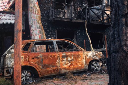 Foto de Irpin, región de Kiev, 2022. Un coche destruido en el patio de una casa. Consecuencias del disparo de cohetes durante la guerra de Rusia contra Ucrania. - Imagen libre de derechos