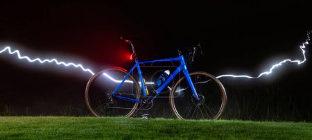 Photo for Gravel bicycle on the lawn at night with a strip of light. - Royalty Free Image