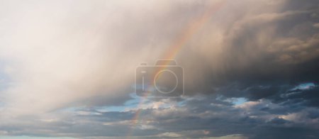 Photo for Rainbow in the cloudy rainy sky - Royalty Free Image