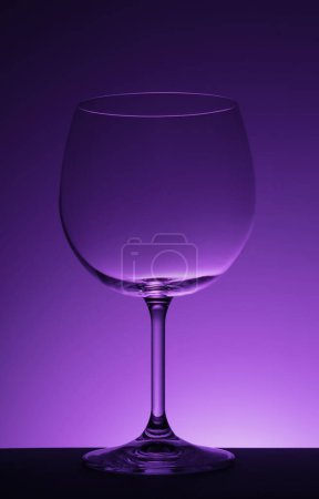 Photo for Empty wine glass on purple background. - Royalty Free Image