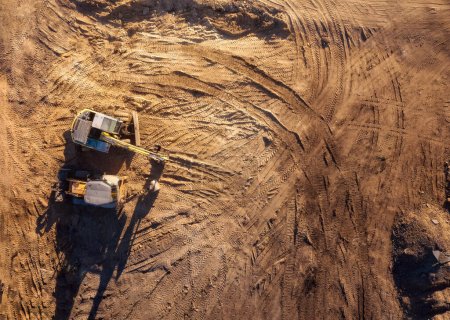 Vista aérea superior del sitio de construcción con tractor y excavadora. Equipo de movimiento de tierras.