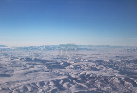 El cielo con nubes y montañas en la nieve. Foto tomada de un avión.