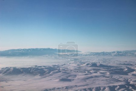 El cielo con nubes y montañas en la nieve. Foto tomada de un avión.