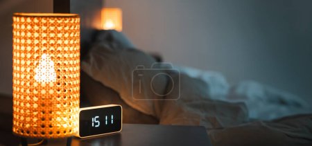 Photo for Smart home devices. Alarm clock on the bedside table. Interior of the bedroom. Night lights connected to the home automation system. Copy space. Horizontal banner. - Royalty Free Image