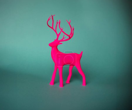 Téléchargez les photos : Figurine imprimée d'un cerf rose sur fond vert. - en image libre de droit