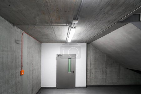 Téléchargez les photos : Escalier en béton dans un immeuble de bureaux. Mur blanc avec une porte - en image libre de droit