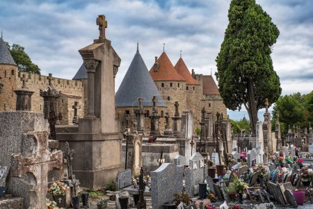 Cementerio de Carcasona con sus lápidas y vista de las murallas de la ciudad de Carcasona en Francia