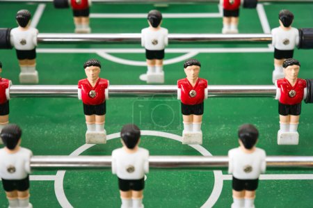 Téléchargez les photos : Gros plan de la table de baby-foot, avec des joueurs miniatures en maillots rouges et blancs. - en image libre de droit