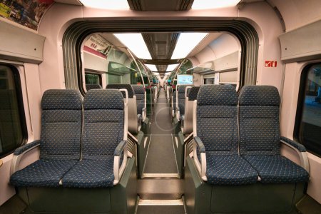 Téléchargez les photos : À l'intérieur d'une cabine de train vide avec des fenêtres montrant qu'il fait sombre à l'extérieur. - en image libre de droit