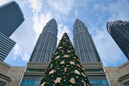 Téléchargez les photos : Kuala Lumpur, Malaisie - 19 décembre 2023 : Arbre de Noël géant au centre commercial Suria KLCC, avec les tours jumelles Petronas en arrière-plan. - en image libre de droit