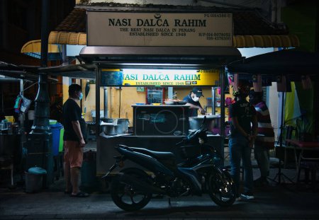 Téléchargez les photos : Penang, Malaisie - 31 octobre 2022 : Les convives qui fréquentent le célèbre étal de bord de route Nasi Dalca Rahim la nuit à Queen Street, établi depuis 1948. - en image libre de droit