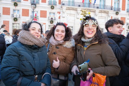 Foto de La gente bebe 12 uvas durante los Preuvas como un ensayo de la tradición de las 12 campanas de Nochevieja en la Puerta del Sol el 30 de diciembre de 2023 en Madrid, España. - Imagen libre de derechos