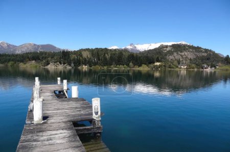 Hermoso paisaje del muelle Lago Nahuel Huapi, rodeado de vegetación verde, en Bariloche en un día de verano.