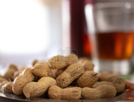 Peanuts in the foreground next to a summer snack on an out-of-focus background