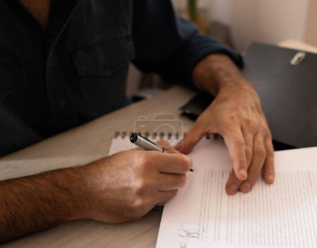 Close up of the hands of a business agent signing a contract. 