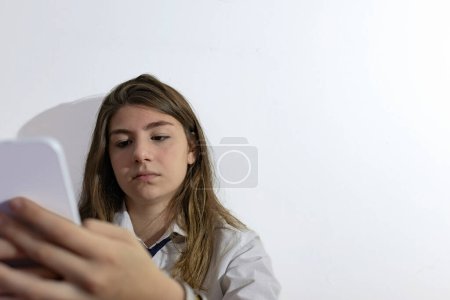 High School Mädchen mit ihrem Handy. Raum für Text. Heller Hintergrund 