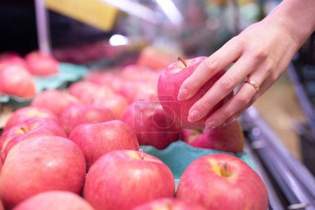Téléchargez les photos : Main d'une femme achetant des pommes - en image libre de droit