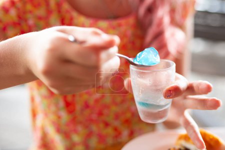 Téléchargez les photos : Un enfant qui mange de la gelée bleue - en image libre de droit