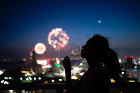 Photo for Woman drinking while watching fireworks - Royalty Free Image