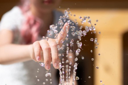 Téléchargez les photos : Main de fille touchant l'eau dans la fontaine - en image libre de droit