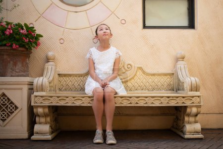 Photo for Girl sitting on a bench and thinking - Royalty Free Image