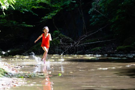 Photo for Girl playing in a mountain stream - Royalty Free Image