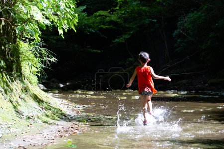 Téléchargez les photos : Fille jouer dans un ruisseau de montagne - en image libre de droit