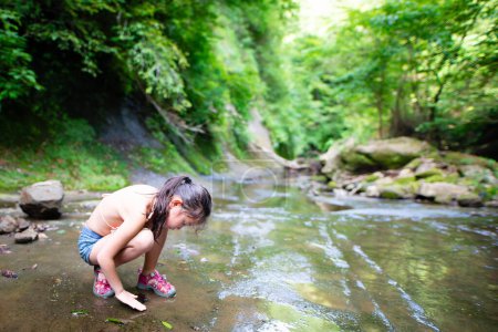 Téléchargez les photos : Fille jouer dans un ruisseau de montagne - en image libre de droit