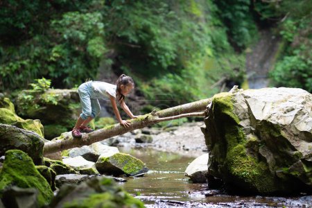 Photo for Girl crossing the log bridge - Royalty Free Image