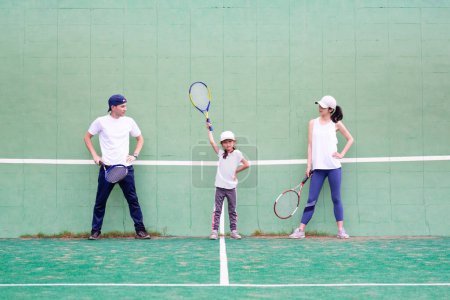 Foto de Padre y madre e hija a la práctica del tenis - Imagen libre de derechos
