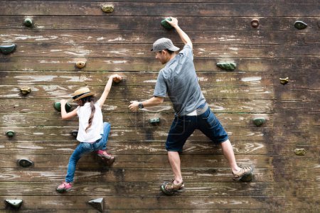 Téléchargez les photos : Père et fille escaladant un mur - en image libre de droit