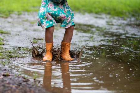 Photo for Child's feet playing in a puddle - Royalty Free Image