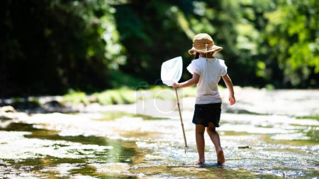 Téléchargez les photos : Enfant jouant dans un ruisseau de montagne - en image libre de droit
