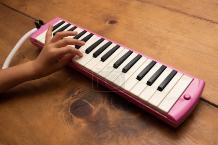 Photo for Child's hand playing the keyboard harmonica - Royalty Free Image