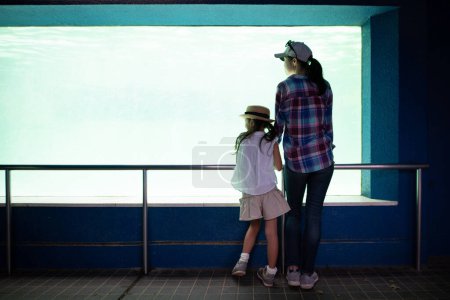 Téléchargez les photos : Parent et enfant regardant l'aquarium - en image libre de droit