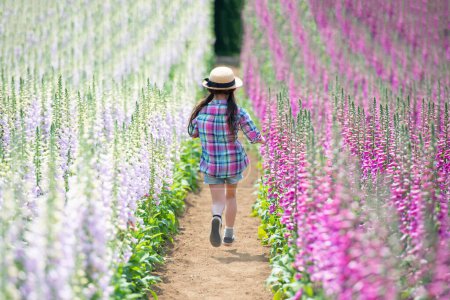 Téléchargez les photos : Fille jouant dans le champ de fleurs - en image libre de droit
