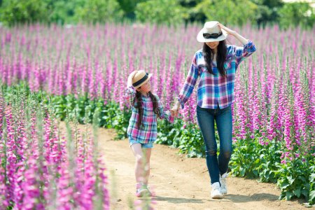 Téléchargez les photos : Belle asiatique fille avec mère dans l 'fleur champ - en image libre de droit