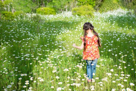 Foto de Chica caminando en el campo de flores - Imagen libre de derechos