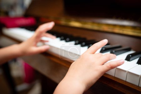 Téléchargez les photos : Main d'enfant jouant du piano - en image libre de droit