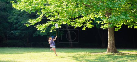 Téléchargez les photos : Une fille qui court pieds nus avec un filet anti-insectes - en image libre de droit