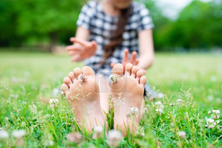 Photo for Children's feet sitting in the field - Royalty Free Image