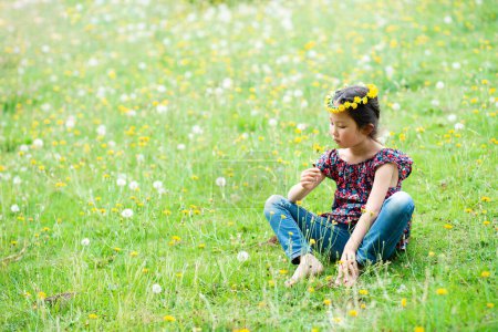 Téléchargez les photos : Fille assise dans un champ de fleurs - en image libre de droit