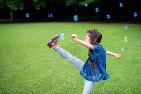 Foto de Joven asiático chica jugando con jabón burbujas en parque - Imagen libre de derechos