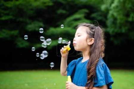 Foto de Chica jugando con burbujas de jabón - Imagen libre de derechos