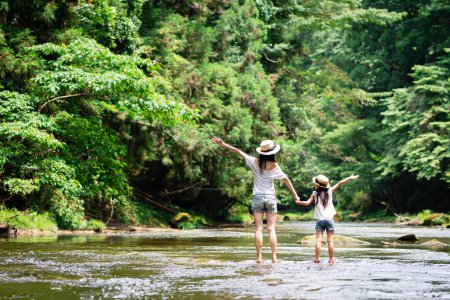 Téléchargez les photos : Mère et fille jouant dans la rivière - en image libre de droit