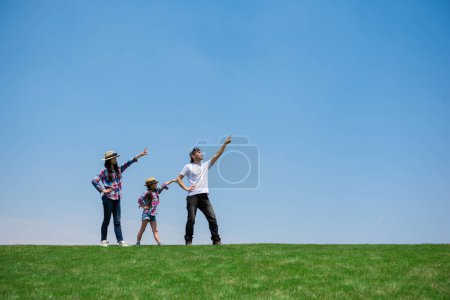 Foto de Familia feliz apuntando al cielo en el prado - Imagen libre de derechos