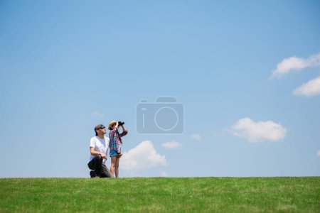 Foto de Padre e hija mirando lejos con prismáticos - Imagen libre de derechos