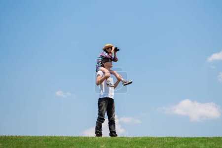 Téléchargez les photos : Père et fille regardant au loin avec des jumelles - en image libre de droit